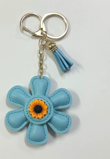 Handmade sky blue leather daisy keychain with yellow center and gold clasp.