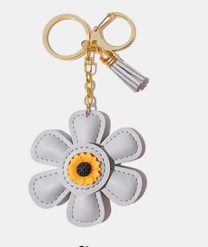 Handmade white  leather daisy keychain with yellow center and gold clasp.