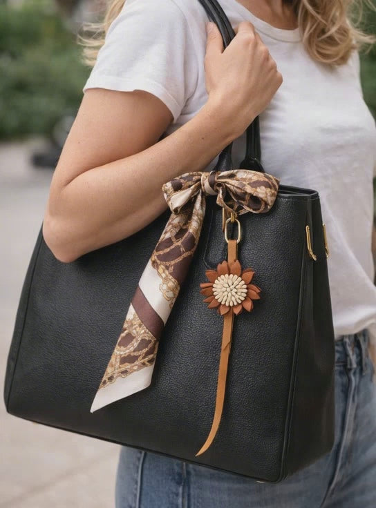 Video of woman walking outside with Autumn Rosette Charm on black purse. 