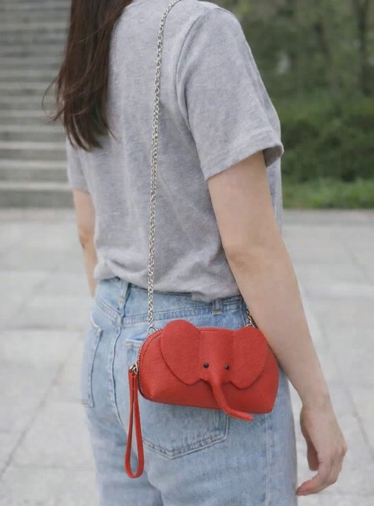 Small genuine leather elephant purse worn as a crossbody mini bag to show size and fit.