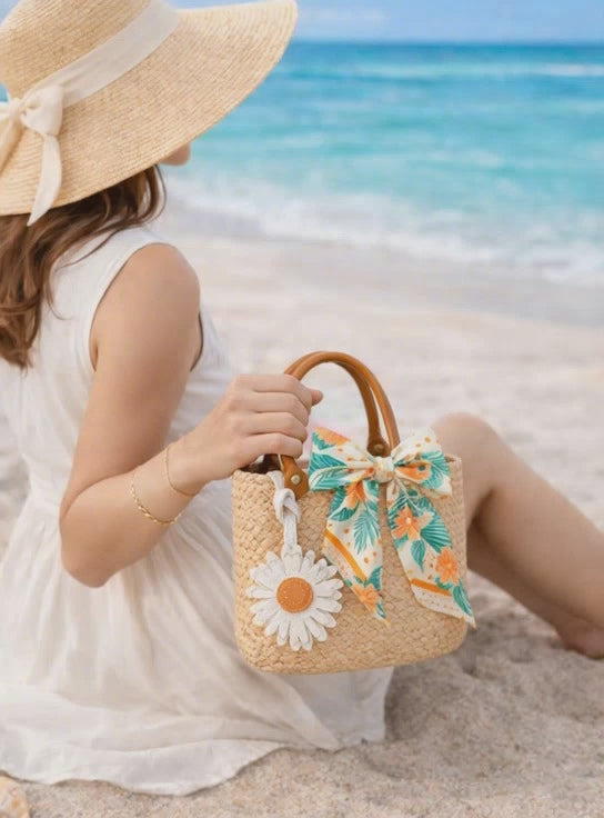 Video of Woman holding straw bag with Sunlit Daisy Leather Bag Charm  and scarf at beach.